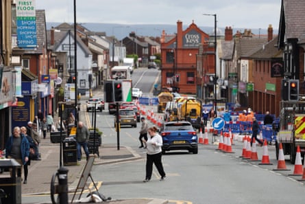 Ashton-in-Makerfield highstreet with people milling around and cars