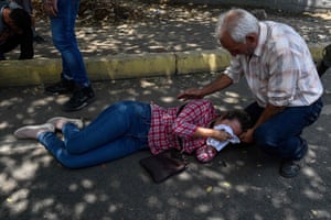 An opposition demonstrator affected by tear gas is assisted during clashes.