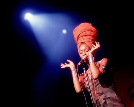 A woman singing on stage with a spotlight on her.