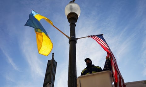 A worker installs Ukrainian and US flags along Pennsylvania Avenue ahead of a visit by Ukraine's President Volodymyr Zelenskiy.