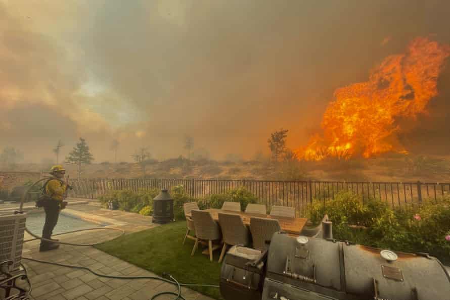 A firefighter prepares to battle the North Fire from a backyard on Via Patina in Santa Clarita, California.