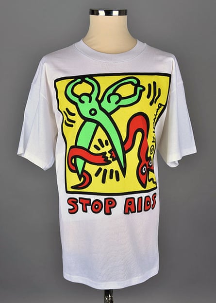 image on t shirt shows people in the shape of scissors cutting a red snake. words say ‘stop aids’