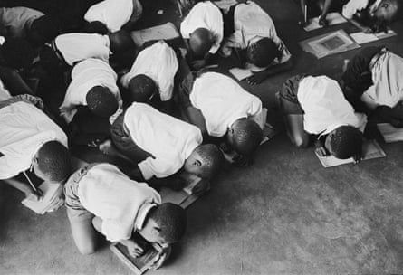 Students kneel on floor to write, South Africa, 1960s