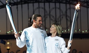 On the eve of the Sydney Olympics, Pat Rafter and Olivia Newton John stand together at the Opera House during the exchanging of the Olympic flame before the lighting of the Olympic Rings on Sydney Harbour Bridge in Australia on 14 September 2000