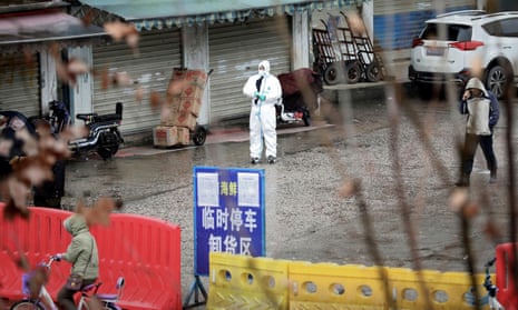 A worker in a protective suit at the seafood market in Wuhan, January 2020, just after the first Covid case had been detected.