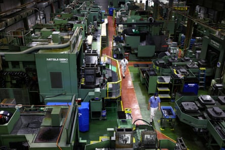 Workers walk between precision-machining machines for automotive parts inside a factory at Kyowa Industrial Co. in Takasaki, Gunma Prefecture, Japan 11 April 2025. REUTERS/Issei Kato/File Photo