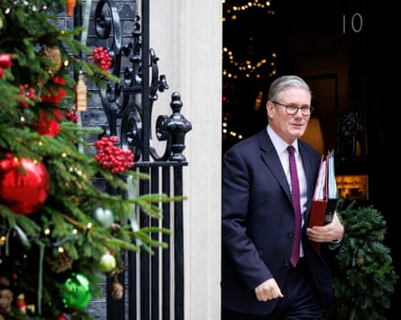 Starmer holds files in his hand as he leaves Downing Street, with a Christmas tree to the side