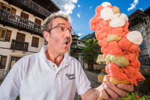 Dimitri Panciera holding cones with lots of mainly orange scoops on it