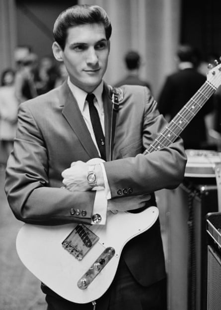Cropper holds a guitar while wearing a suit in New York City, 1967.