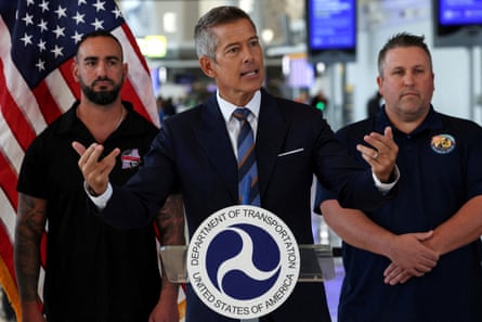 Man in suit speaks at lectern marked ‘department of transportation’ with hands gestured