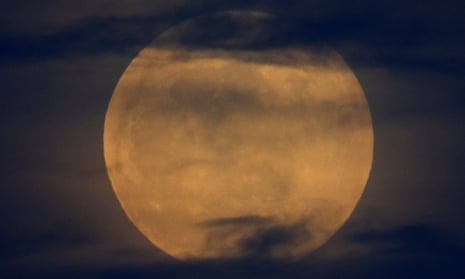 Before the super blood wolf moon lunar eclipse, the full moon rises through the clouds in California.