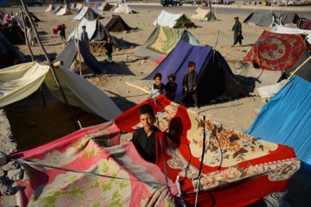 Afghan children who were displaced by drought look from their tents at a camp for IDPs in the Injil district of Herat province, in 2018.