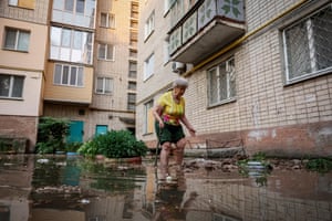 Oleksandra walks around her house on a flooded street, in Kherson.