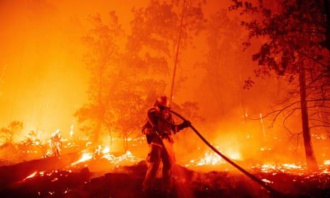 A firefighter douses flames in Madera County, California, September 2020. 