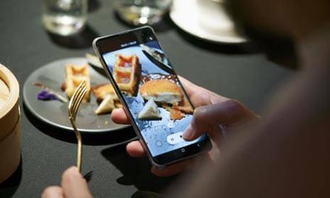 mobile phone takes video of a meal featuring a nugget made from lab-grown chicken meat
