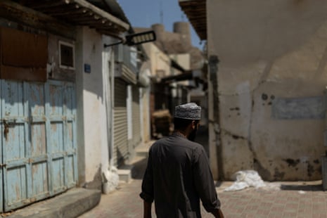 A man walks through a street in Muttrah in Muscat, Oman
