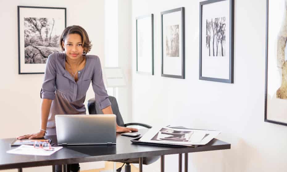Black woman using laptop in art gallery office