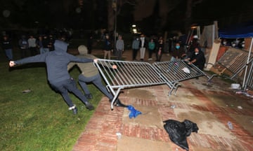 Counter-protesters try to remove barricades at a pro-Palestinian encampment on the University of California, Los Angeles campus.