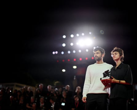 Rachel Szor and Yuval Abraham standing with the special jury award against spotlights and press photographers