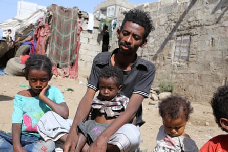 Juma’n Abdullah Hasan cradles his three-year-old son in Ibb city, Yemen