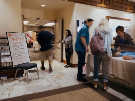 people at check-in desk of hotel. white board says ‘maui medic’