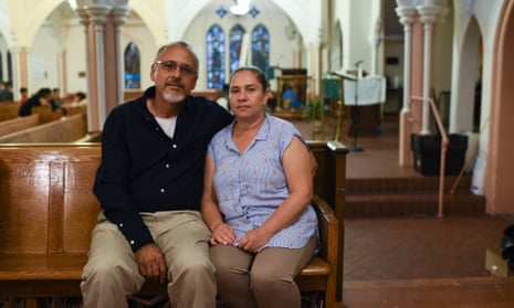 a couple sitting on a pew in a church