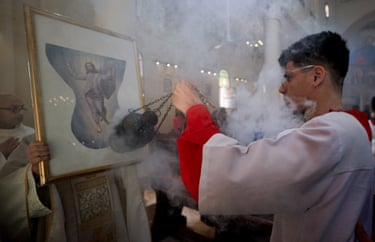 A young man uses incense in front of a religious icon in Gaza City