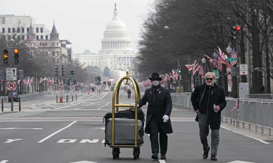 Le danois Rozario, à gauche, fait rouler les bagages d'un client sur Pennsylvania Avenue jusqu'à l'hôtel Trump à Washington le 15 janvier 2021. L'inauguration de Joe Biden cinq jours plus tard a marqué un moment inquiétant pour la fortune de l'hôtel.