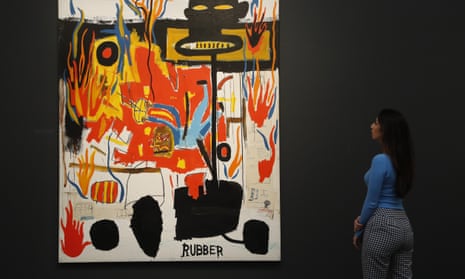 A Sotheby’s employee looks at genuine Jean-Michel Basquiat painting, entitled Rubber during a sale in London. 