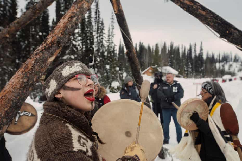 People stand in ceremony as police arrive to enforce Coastal GasLink’s injunction at Unist’ot’en Healing Centre near Houston, B.C. on Monday, February 10, 2020.