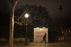 A demonstrator spray paints in Catalan ‘Freedom for Hasel’ during a protest condemning the arrest of rap artist Pablo Hasél in Barcelona.