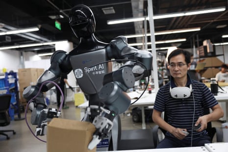An employee wearing motion-tracking equipment uses a controller to operate a Moz1 robot to perform tasks at the data training centre at the headquarters of Spirit AI in Beijing, China, September 17, 2026.