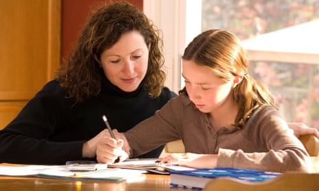 A mother helping her daughter with schoolwork at home. Picture posed by models.