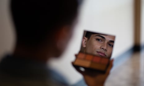 Young man looks at himself in the mirror