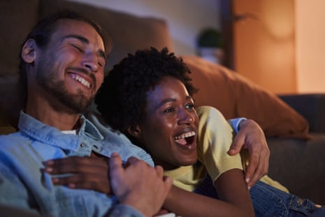 A couple cuddling on a sofa