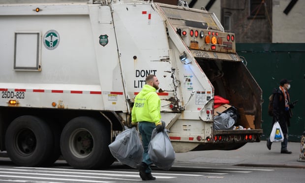 Sanitation workers collect trash along the streets in midtown Manhattan on 29 April.