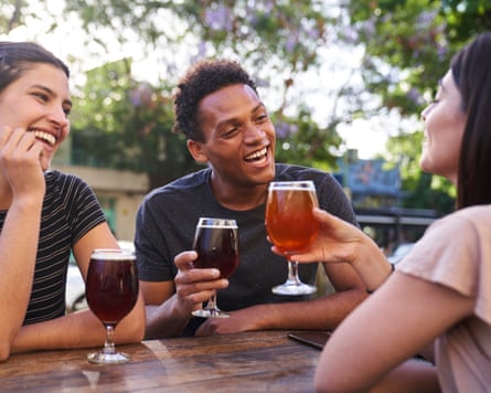 Diverse group of happy friends hanging out drinking craft beer at happy hour