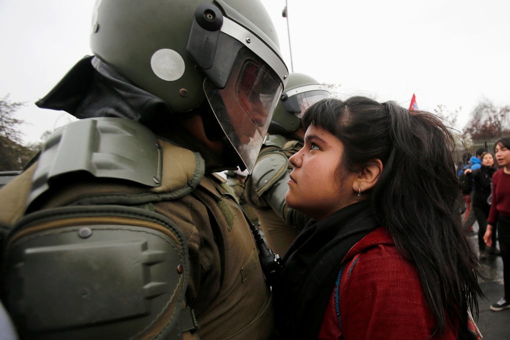 Photo of young woman confronting heavily armed riot police