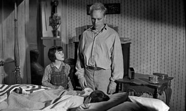 Duvall standing over a child lying in bed