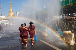 Yangon, MyanmarWomen walk under a rainbow during the Buddhist New Year, known locally as “Thingyan”