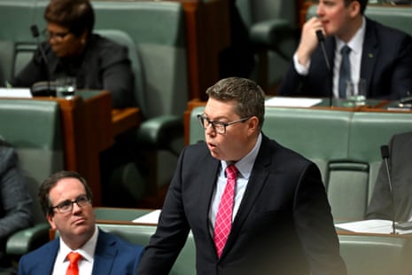 A man in a dark suit and red tie.