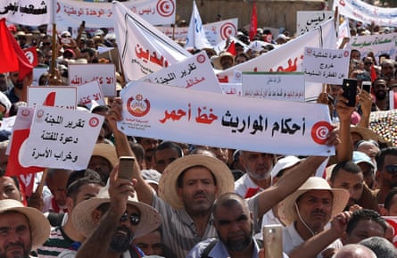 Hundreds of Tunisians hold pro-conservative signs during a protest against proposed reforms opposed by conservative Muslims, which include equal inheritance rights for women and decriminalising homosexuality, in August 2018, Tunis