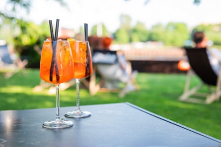 A refreshing closeup of two bright orange Aperol spritz cocktails