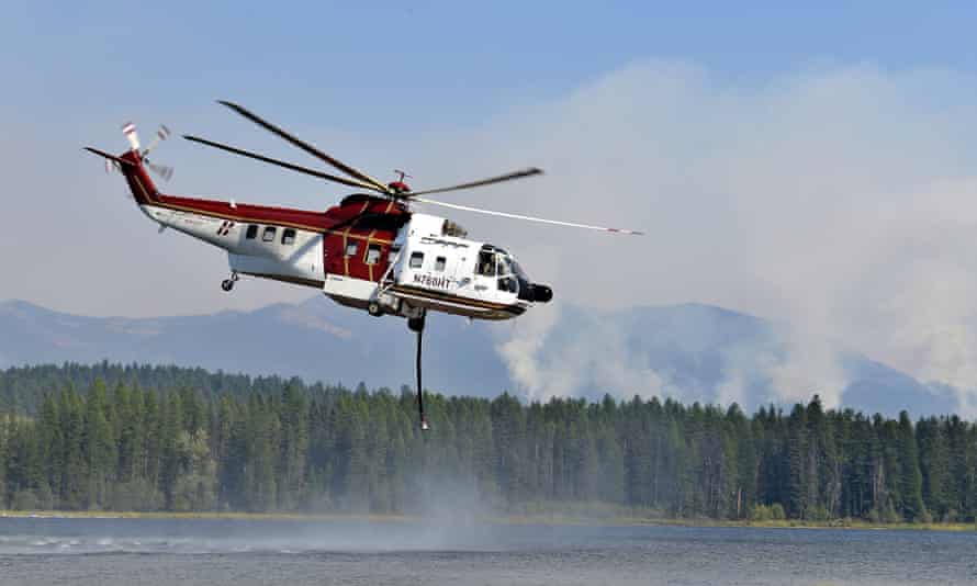 A helicopter fills its water tank as it readies to battle a wildfire. Across Montana, wind is fanning numerous fires in the drought-addled state.