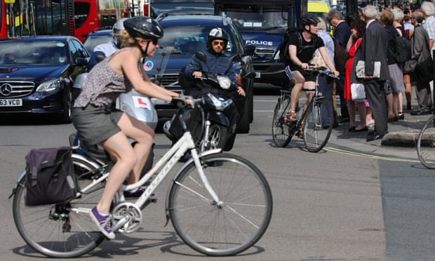A female cyclist crossing a busy junction in Parliament Square, London.
