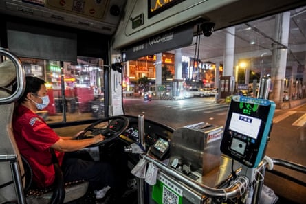 A man driving a bus at night in Guangzhou