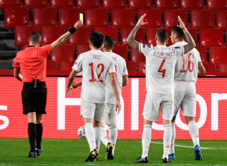 Referee Marco Guida shows the yellow card to Iñigo Martínez of Spain.