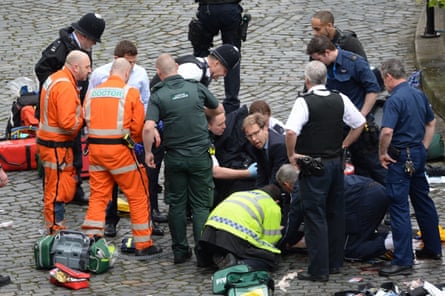 A chaotic scene outside the Houses of Parliament with Tobias Ellwood and some emergency service workers crouched on the ground trying to resuscitate PC Keith Palmer, while others stand watching