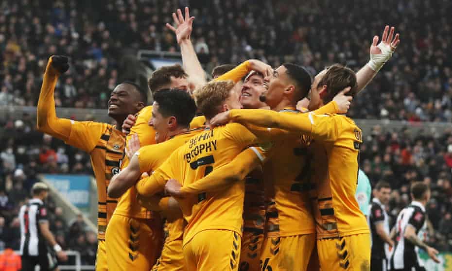 Joe Ironside is mobbed by his Cambridge teammates after scoring the winner at Newcastle
