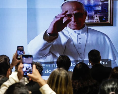 People watch a video of Pope Leo XIV at the Amazonian Museum in Belem, Brazil.